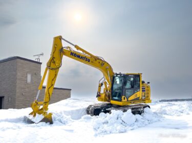 ユンボで雪山崩し作業