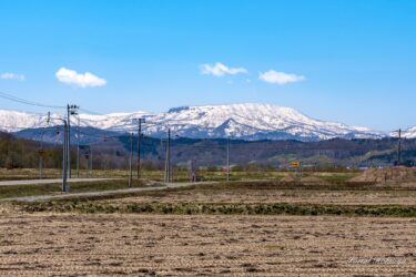 春の田畑を見守る恵岱岳