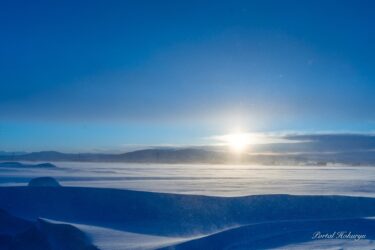 Cahaya yang menyinari padang salju keperakan dan langit musim dingin berwarna lapis lazuli