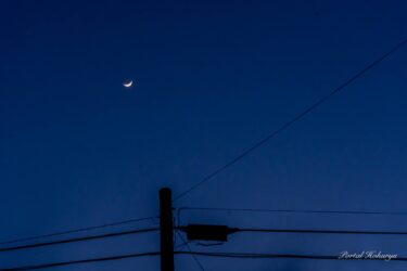 濃藍色の冬空に輝く三日月