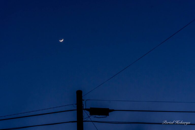 濃藍色の冬空に輝く三日月